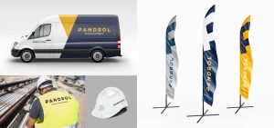 Pandrol logos on: a van, a hard hat, a safety vest and banners