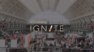 Ignite 2018 logo with conference hall full of people as the background